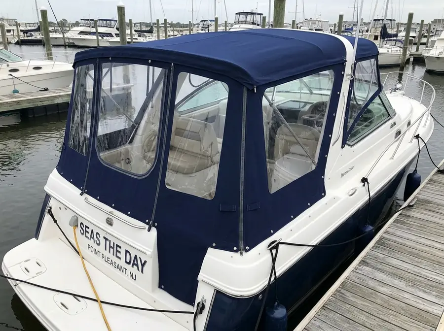 Cabin cruiser with a navy canvas enclosure and clear windows